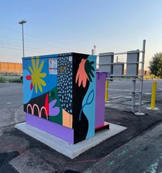 a colorful box sitting in the middle of a parking lot