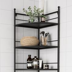 three tiered shelf with various items on it in a white tiled bathroom, next to a toilet