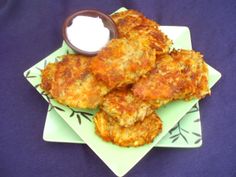 some food is sitting on a green plate with a small bowl of ranch dressing next to it