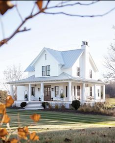 a large white house sitting on top of a lush green field