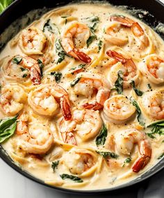 a skillet filled with shrimp and spinach