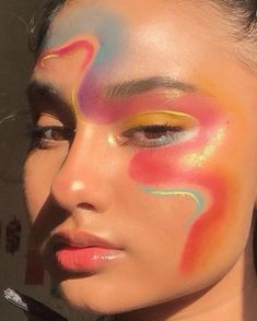 a woman with her face painted like an abstract painting on her face and the words love written in it