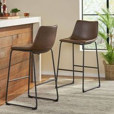 two brown barstools sitting next to each other in front of a counter top