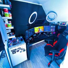 a gaming room with two monitors and chairs