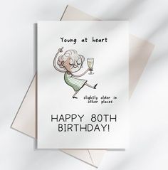 a birthday card with an image of a woman holding a glass of wine and the words, young at heart slightly older in other places