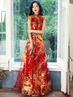 This set of long red wedding cheongsam dress is unique, showing a strong retro atmosphere and noble and elegant style. The whole garment is made of high-quality fabric, with smooth touch and bright luster. Wearing it, you will instantly become a star in the spotlight. The upper part of the dress is tight-fitting design, highlighting your perfect figure, and the details are exquisite. The golden phoenix decoration on the neckline, waist and skirt design adds more romantic feeling, making you more immortal. The skirt part adopts loose A-shape design, creating a broad and lazy feeling, which makes people unconsciously think of elegant melody. This red cheongsam dress is very suitable for all kinds of formal occasions, such as dinner, wedding, concert, etc., so that you can stand out in these Chinese Inspired Dress, Red Wedding Party, Brain Creative, Chinese Style Wedding Dress, Red Chinese Wedding Dress, Burgundy Wedding Dress, Modern Chinese Wedding, Wine Red Wedding, Tea Ceremony Dress