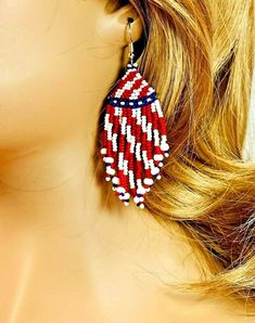 red, white and blue beaded earrings on top of a mannequin head