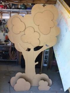 a large wooden cutout of a tree with clouds in the shape of hearts on it