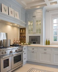 a kitchen with white cabinets and silver appliances