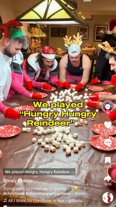 a group of people sitting around a table covered in cookies and marshmallows