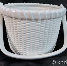 a large white basket sitting on top of a table