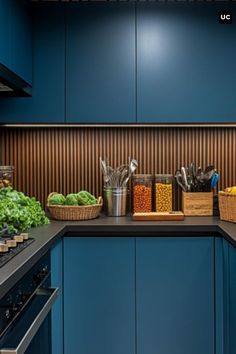 a kitchen with blue cabinets and black countertops has food in baskets on the counters