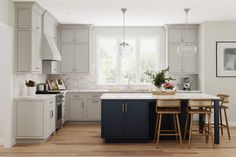 a kitchen with white cabinets and wooden floors