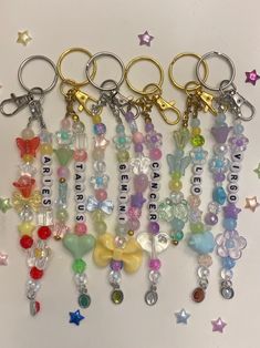 several key chains with charms attached to them on a white surface surrounded by stars and confetti