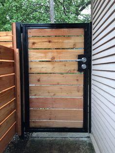 an open wooden gate with black iron bars