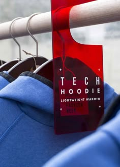 there is a red sign that says tech hoodie hanging on a clothes hanger