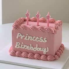 a pink princess birthday cake with candles on it