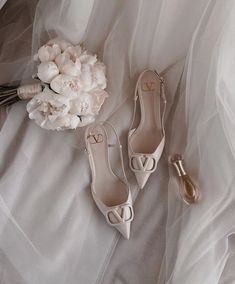 the bridal shoes are next to a bouquet of flowers