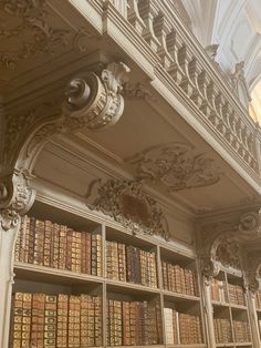 an old library with many books on it's shelves and ornate carvings around the bookcases