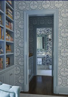 an open door leading into a room with blue and white wallpaper on the walls