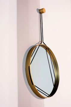 a round mirror hanging from the side of a wall