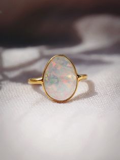 This bold gold statement ring features organic shaped Fire Opal that shines from within. This gorgeous gold ring is sure to become an everyday staple. Wear it solo or stack it with our other favorite rings.✦ DETAILS ✦✧ Name: Hinuhinu (HEE noo HEE noo) - bright, glittering, splendid.✧ Available in whole sizes 5-9. ✧ Synthetic Fire Opal Stone.✧ 18kt Gold Vermeil.✧ All Ke Aloha Jewelry pieces come packaged thoughtfully, beautifully, and ready for gift giving. Opal Ring Simple Gold, Wide Band Ring Opal, Opal Ring Simple Capucinne, Luxury Minimalist Yellow Gold Opal Ring, Natural Fire Opal Ring, Modern Opal Ring, Opal Rock, Opal Statement Ring, Gold Moonstone Ring