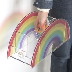 a person holding a box with a rainbow design on it