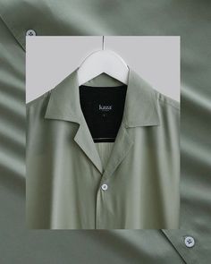 a green shirt hanging on a white hanger