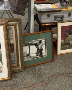 several framed pictures are sitting on the ground