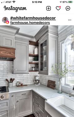 a kitchen with gray cabinets and white counter tops