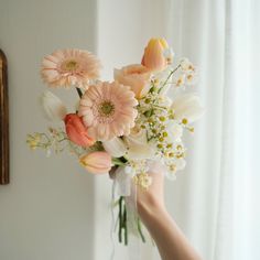 a person holding a bouquet of flowers in their hand