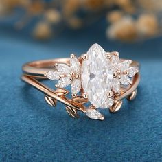 an oval shaped diamond ring with leaves on it