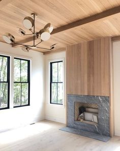 an empty living room with wood paneling on the ceiling and windows in the wall