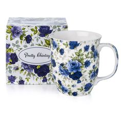 a coffee cup with blue flowers on it next to a box