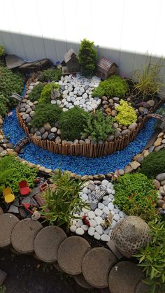 an aerial view of a garden with rocks, plants and stones on the ground in front of a building