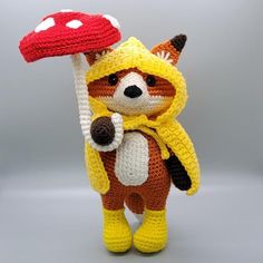 a crocheted stuffed animal holding a mushroom