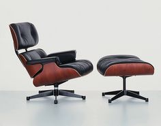 an eames lounge chair and ottoman with black leather upholstered on the back