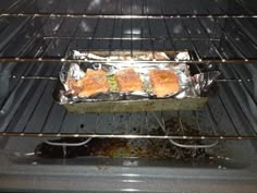 some food is cooking in an oven on tin foil