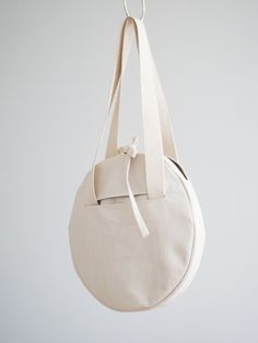 a white round bag hanging from a hook