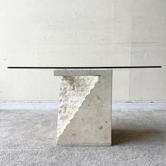 a table made out of concrete with a glass top