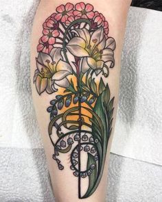 a tattoo with flowers on the leg