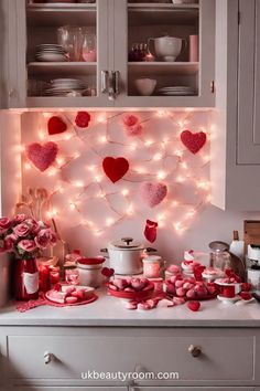 valentine's day decorations on the kitchen counter with pink roses and hearts hanging above