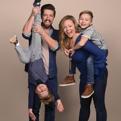 a man, woman and child posing for a photo with an umbrella in the air