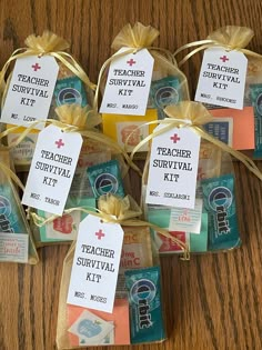 six teacher survival kits wrapped in twine and tied with yellow ribbon on a wooden table