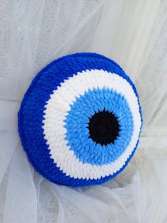 a blue and white knitted object with an eyeball