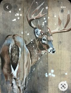 an image of a deer painted on wood planks with snow falling off it's antlers