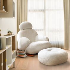 a living room with a white chair and ottoman next to a book shelf filled with books