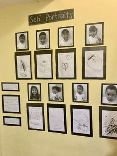 a group of children's drawings are displayed on the wall in front of them