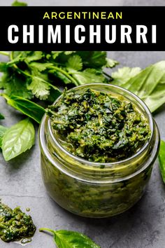 an image of homemade pesto sauce in a jar with basil leaves on the side