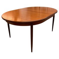 an oval wooden table with two leaves on the top and one leaf at the bottom